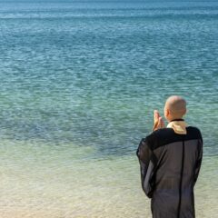 海に手を合わせる僧侶